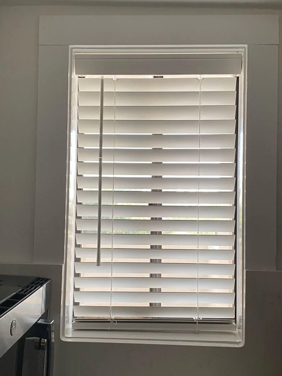 White plantation shutters fitted to a window